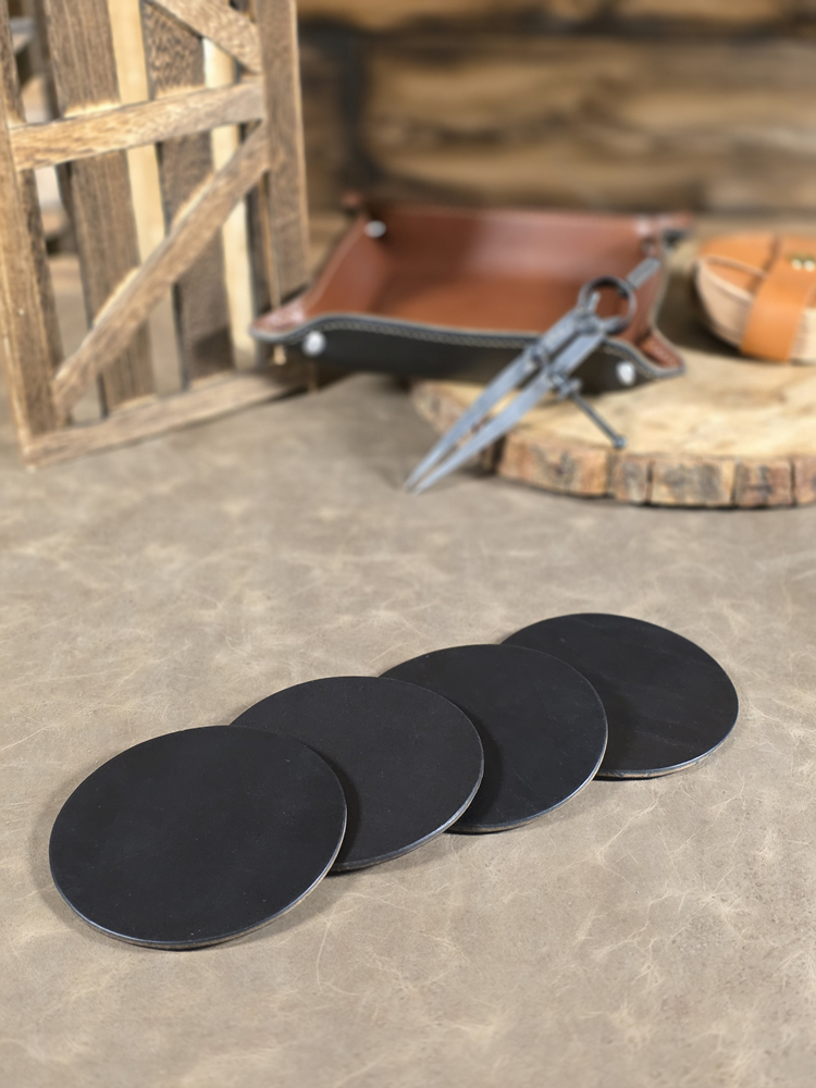 Set of black coasters on a stone surface with rustic background