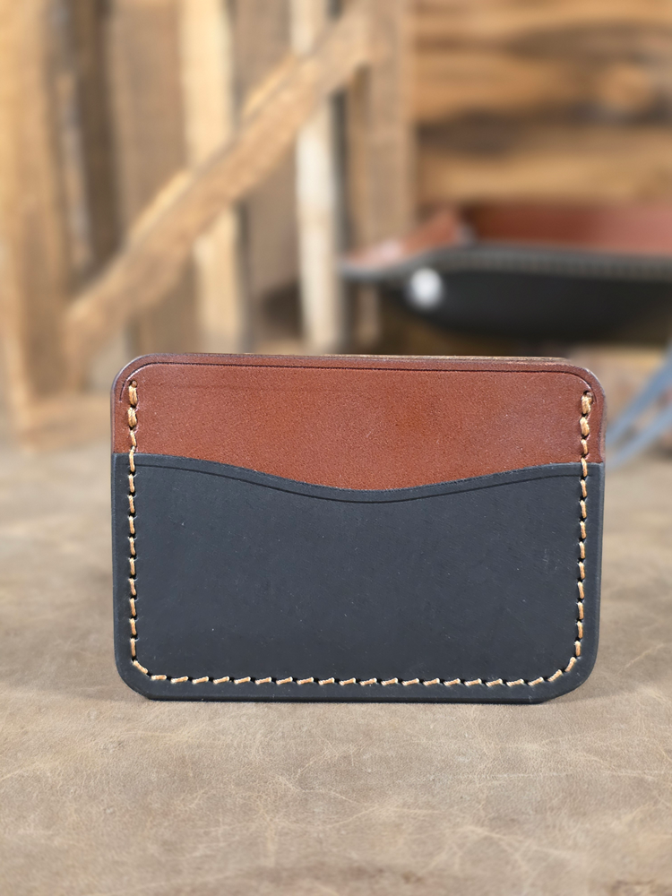 Brown and black leather card wallet with a blurred background