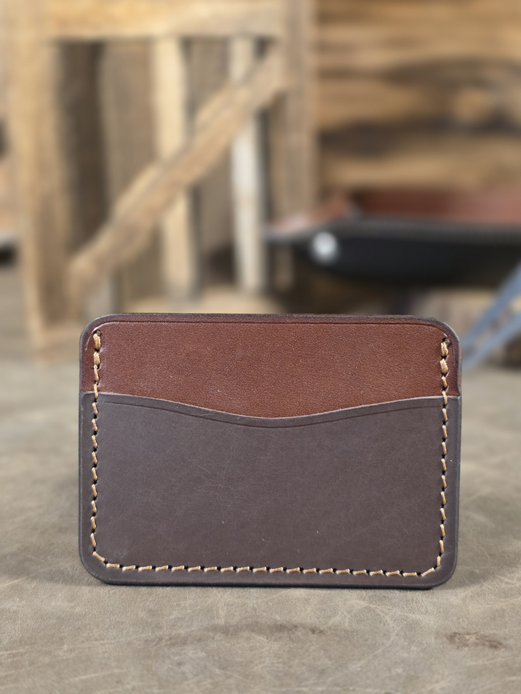 Brown and chocolate colored leather card wallet with a blurred background