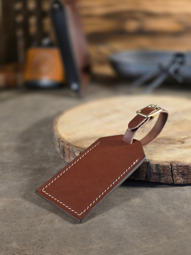 Brown leather luggage tag on a wooden surface with a blurred background