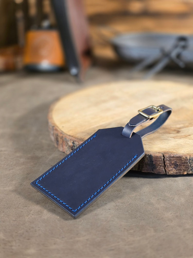 Blue leather luggage tag on a wooden surface with a blurred background