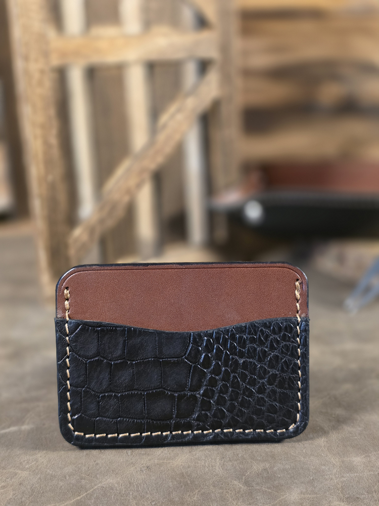 Black alligator minimalist card wallet with a blurred background