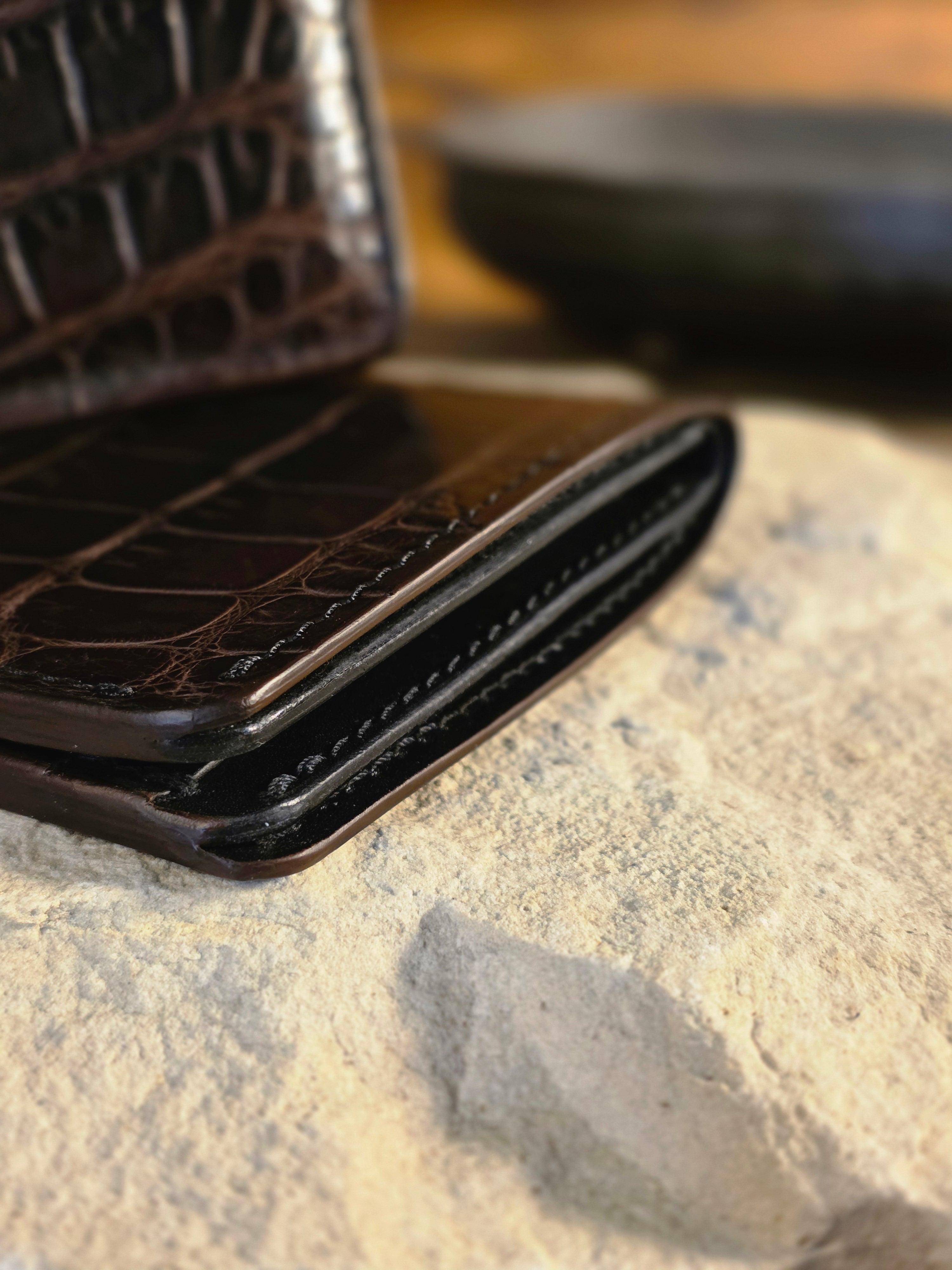Close-up of a textured black wallet on a stone surface