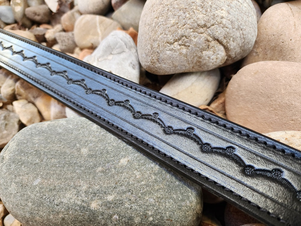 close up of a black leather replica of Wild Bill Hickok's belt, the belt features scallop pattern tooling.