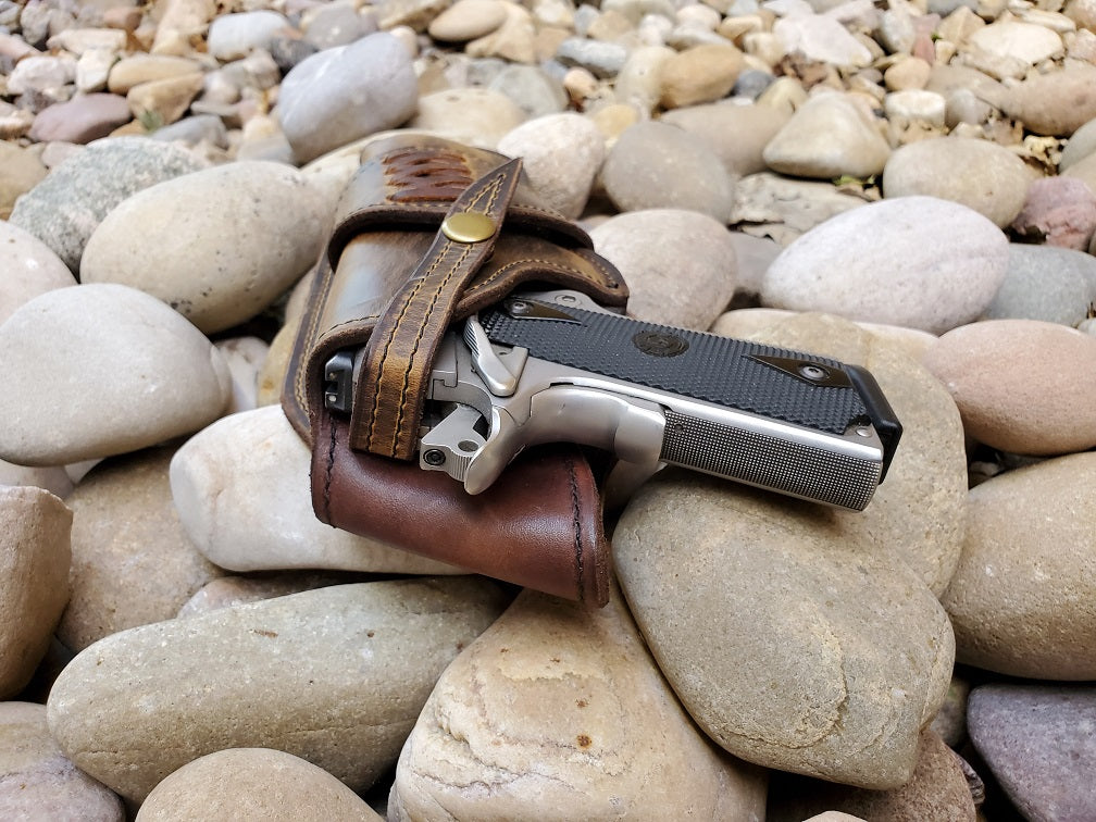 Rear view of a leather 1911 holster. Veg tan lined with a brown rustic exterior and snap retention.