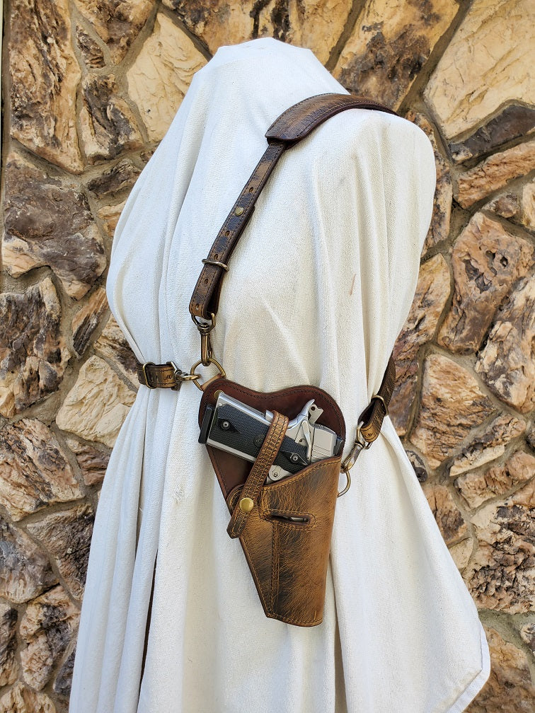 Rustic WWII Tanker shoulder holster on a canvas draped mannequin over a jagged brown rock background.