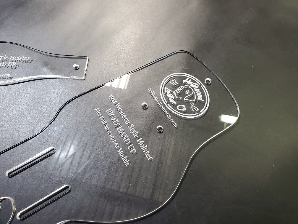 A closeup of the acrylic holster pattern shows the Hellhound Leather Co logo and the engraved labeling of the pattern.