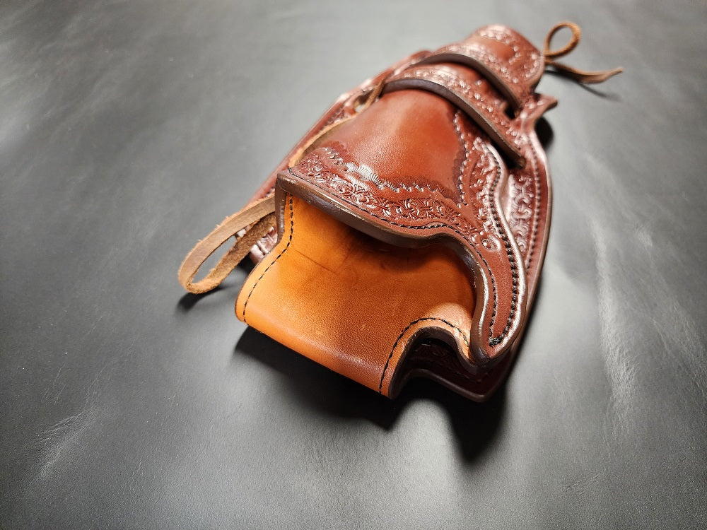 View of the mouth end of the holster, the exterior is brown leather and the interior is russet leather, the piece is stitched with black thread.