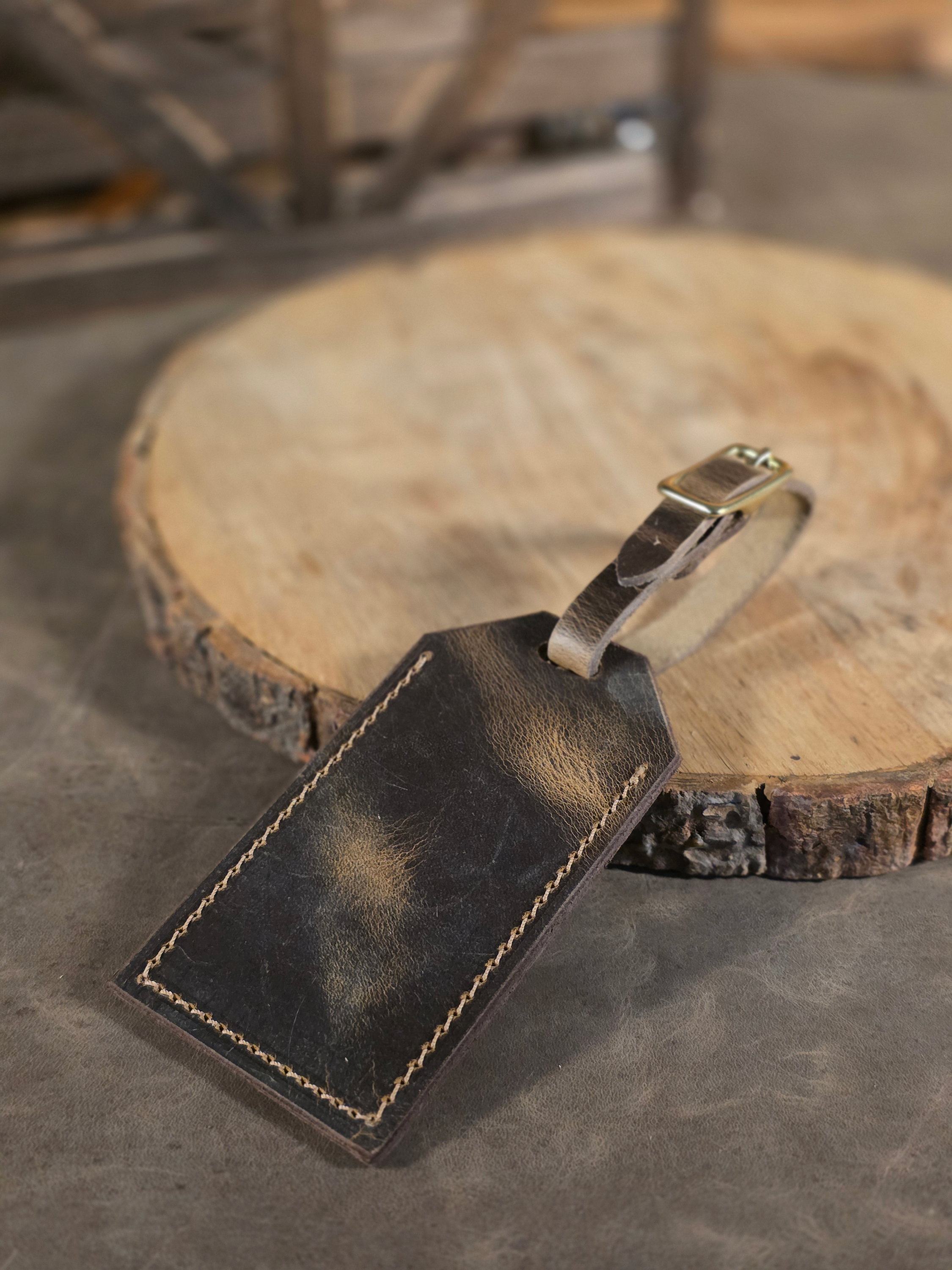 Rustic style leather luggage tag on a cut log round wooden surface