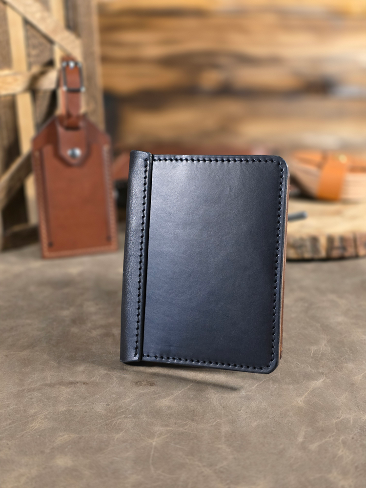 Black leather passport travel wallet on a textured surface with blurred background