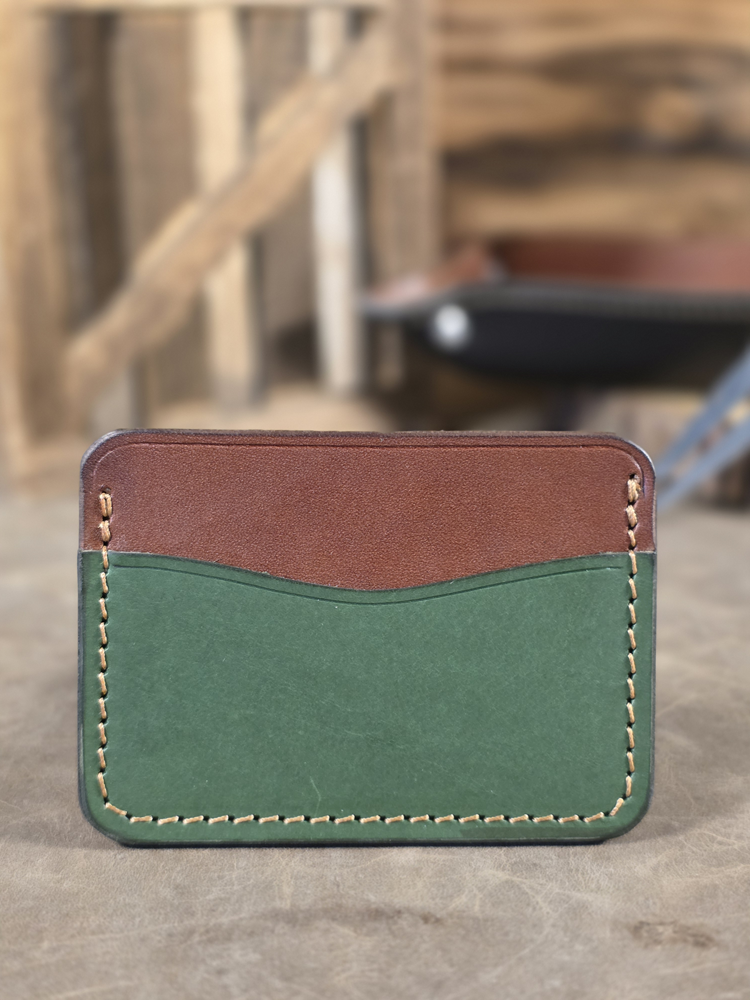Green and brown leather wallet on a wooden surface with blurred background