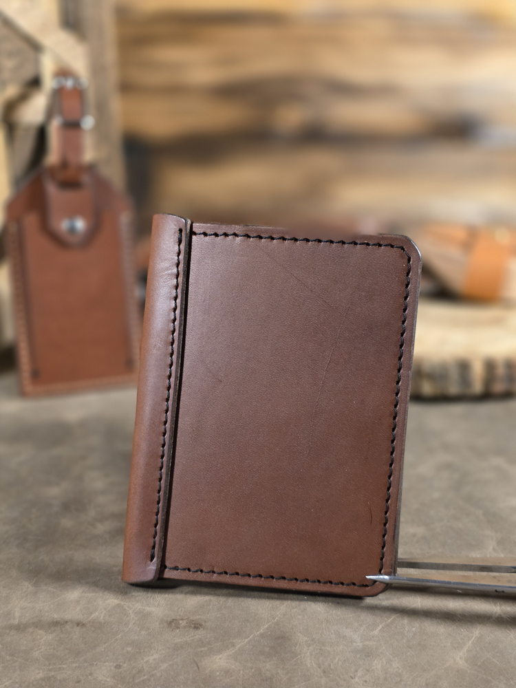 Brown leather wallet on a wooden surface with blurred background