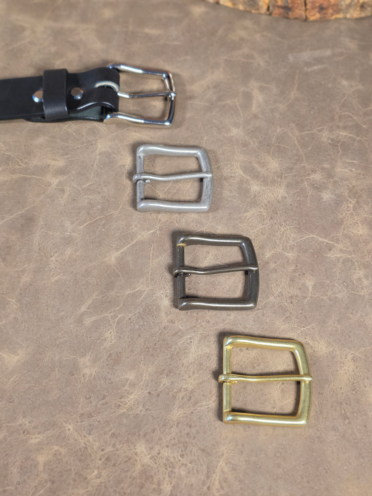 Set of different belt buckles in a variety of finishes on a textured surface