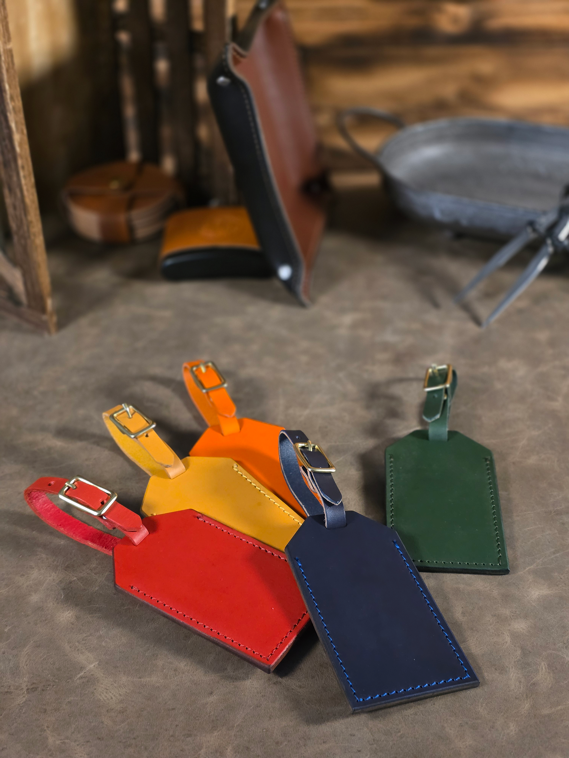 Colorful leather luggage tags on a textured surface with blurred background