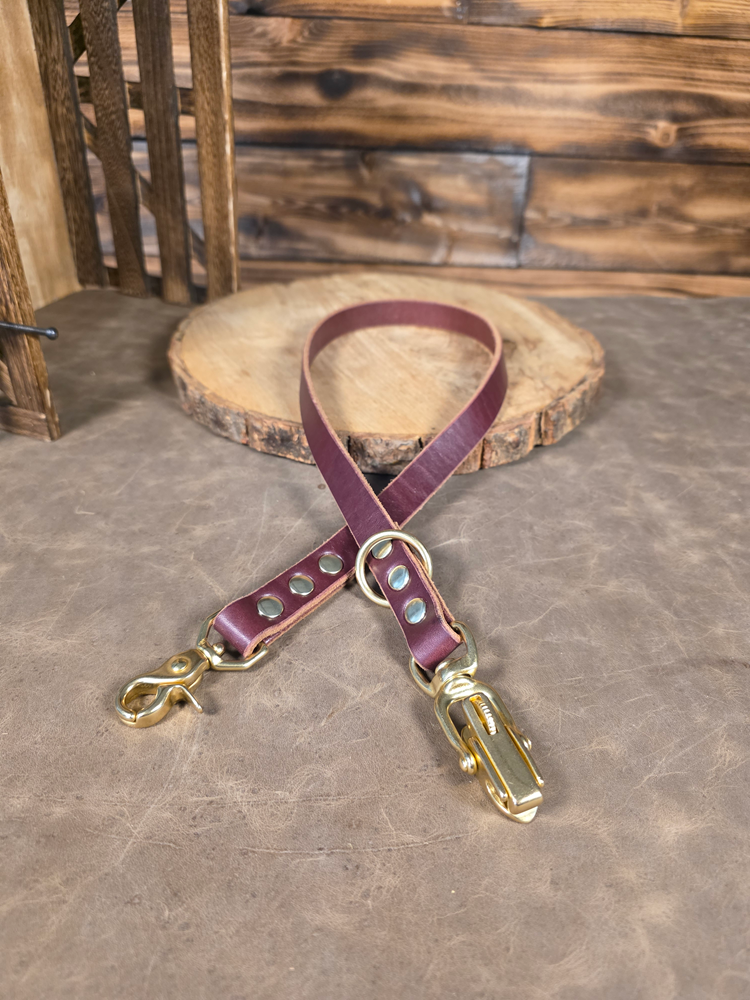 Looped oxblood leather Jaeger lead extension piece with a blurred wooden background