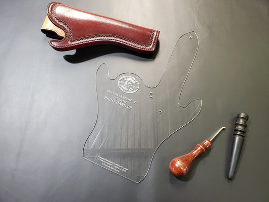 Clear 1/8" thick acrylic leathercraft pattern of a California slim style holster sits next to a brown leather holster and a few common leathercraft tools. 