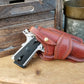 Beautiful full grain leather holster with a stamped edge pattern sits next to a wooden crate and aluminum tin. 