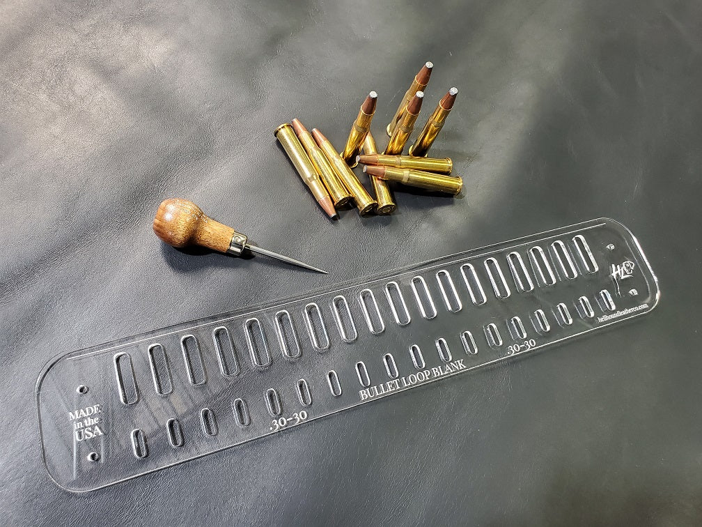 An acrylic bullet loop pattern used in leathercraft to mark the spacing between bullet loops on a western gun belt sits next to a pile of .30-30 bullets.