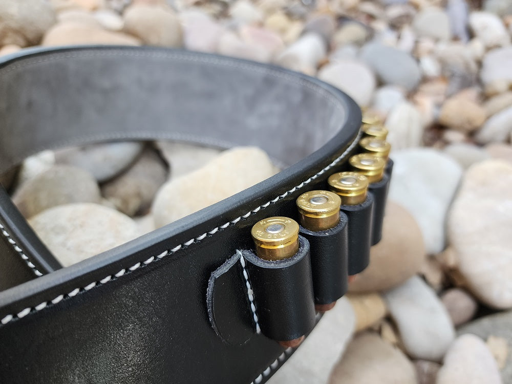 Up close view of the bullet loops on the Angel Eyes gun rig, in frame are seven bullets, the pieces is made with black leather and white stitching.