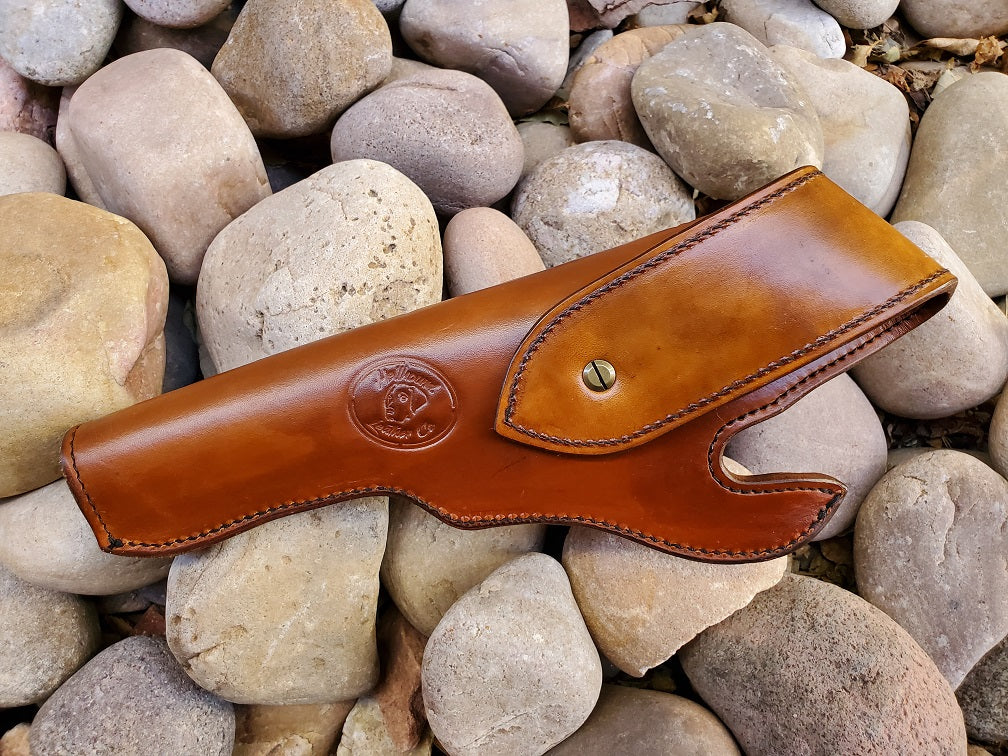 View from underside of brown leather holster, the holster is stamped with company logo and finished with solid brass hardware and black stitching.
