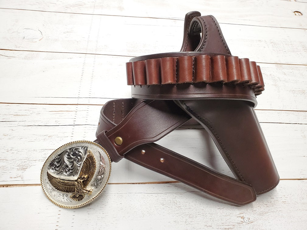 View of the brown leather Lone Wolf Mcquade holster and belt focusing primarily on the bullet loops stitched onto the belt, laying on wooden slats.