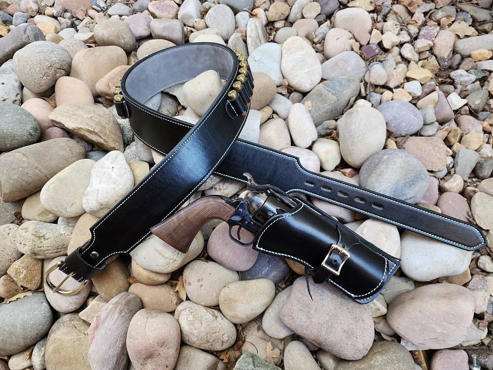 Van Cleef's Angel Eyes rig made of black leather with suede interior, the belt features solid brass hardware with bullet loops. Next to the belt is the holster made of black leather.